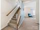Carpeted staircase with white railing and wooden banister leading to the home's upper level at 176 Jennymarie Rd, Mooresville, NC 28115