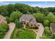 Aerial view of a stunning brick home with mature landscaping and a circular driveway creating great curb appeal at 2304 Thunder Gulch Ct, Waxhaw, NC 28173