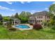 Aerial view of a house with a pool and backyard landscaping, screened porch, and brick exterior at 2304 Thunder Gulch Ct, Waxhaw, NC 28173