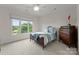 Sunny bedroom with an antique wood dresser, white trim and carpet at 2304 Thunder Gulch Ct, Waxhaw, NC 28173