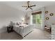Cozy bedroom with a white bed frame, soft carpet, natural light, and a ceiling fan at 2304 Thunder Gulch Ct, Waxhaw, NC 28173
