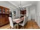 Formal dining room featuring a long wooden table, chandelier, and custom built-in cabinetry with bar area at 2304 Thunder Gulch Ct, Waxhaw, NC 28173