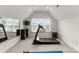 Bright exercise room featuring a treadmill, window and a wall-mounted TV at 2304 Thunder Gulch Ct, Waxhaw, NC 28173