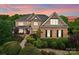 Striking two-story brick home featuring a stone accent, manicured landscaping, and a welcoming front porch perfect for relaxing at 2304 Thunder Gulch Ct, Waxhaw, NC 28173