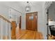 Bright and inviting foyer featuring hardwood floors, decorative lighting, and a beautiful wood front door at 2304 Thunder Gulch Ct, Waxhaw, NC 28173