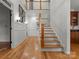 Elegant hallway featuring hardwood floors, wainscoting, and a staircase leading to the upper level at 2304 Thunder Gulch Ct, Waxhaw, NC 28173