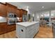 Open kitchen featuring a marble island, custom cabinets, stainless appliances, and hardwood floors at 2304 Thunder Gulch Ct, Waxhaw, NC 28173