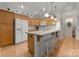 Well-lit kitchen with island, countertop seating, light wood cabinets, and white appliances at 2304 Thunder Gulch Ct, Waxhaw, NC 28173