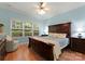 Serene main bedroom featuring a large bed, wood floors, and natural light from a big window at 2304 Thunder Gulch Ct, Waxhaw, NC 28173