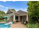 Outdoor pool area with brick pool house, waterfall feature, and outdoor seating on a sunny day at 2304 Thunder Gulch Ct, Waxhaw, NC 28173