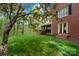 Landscaped backyard featuring a lush lawn and a glimpse of the screened porch at 2306 Beechwood Dr, Waxhaw, NC 28173