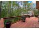 Open wooden deck with table and chairs, surrounded by a lush treeline at 2306 Beechwood Dr, Waxhaw, NC 28173