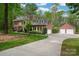 Brick home with a long driveway leading to a detached garage with two garage doors, and mature trees at 2306 Beechwood Dr, Waxhaw, NC 28173