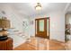 Welcoming foyer with hardwood floors, a wooden front door with glass insets, and a staircase with white banisters at 2306 Beechwood Dr, Waxhaw, NC 28173