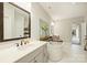 Modern bathroom with soaking tub, white countertops and view to a hall at 2541 Kenmore Ave, Charlotte, NC 28204