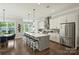 Open concept kitchen with stainless steel appliances, a gray island with seating, and hardwood floors at 2541 Kenmore Ave, Charlotte, NC 28204