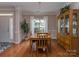 Comfortable dining area with a wooden table set, hardwood floors, and a large window at 2603 Willis Dr, Harrisburg, NC 28075