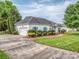 Well-maintained exterior with a long driveway leading to a single-car garage and manicured landscaping at 2603 Willis Dr, Harrisburg, NC 28075