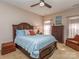 Cozy main bedroom with a dark wood bed frame, ceiling fan, and a plush armchair by a window at 2603 Willis Dr, Harrisburg, NC 28075