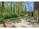 A concrete patio area surrounded by lush trees in the backyard provides a relaxing outdoor space at 2710 Red Bud Ln, Fort Mill, SC 29715