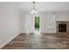 Dining area featuring wood floors, a modern chandelier, slider doors to the backyard, and a stone fireplace at 2710 Red Bud Ln, Fort Mill, SC 29715