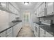 Bright kitchen featuring white cabinets, stainless appliances, tile flooring, and a view of the backyard at 2710 Red Bud Ln, Fort Mill, SC 29715