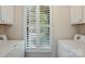 Laundry room with a large window with shutter, washer and dryer, and white cabinets at 2710 Red Bud Ln, Fort Mill, SC 29715