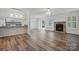 Bright living room featuring wood floors, a stone fireplace, shutters, and modern ceiling fan at 2710 Red Bud Ln, Fort Mill, SC 29715