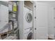 Convenient laundry room with stackable washer and dryer units, and a storage area at 2810 Selwyn Ave # 410, Charlotte, NC 28209