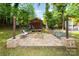 Landscaped backyard featuring a firepit, shed, seating, string lights, and a garden at 3004 Point Clear Dr, Tega Cay, SC 29708