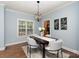 Dining room with modern chandelier, seating for four, and view of kitchen at 3004 Point Clear Dr, Tega Cay, SC 29708