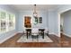 Elegant dining room with hardwood floors, modern light fixture, and view to the kitchen at 3004 Point Clear Dr, Tega Cay, SC 29708