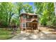 Charming two-story home featuring wood siding, a cozy front porch, and mature trees on a sunny day at 3004 Point Clear Dr, Tega Cay, SC 29708