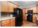 Efficient kitchen featuring wooden cabinets, black appliances, and ample counter space at 3004 Point Clear Dr, Tega Cay, SC 29708