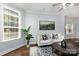 Comfortable living room featuring a white sofa, hardwood floors, and natural light from large windows at 3004 Point Clear Dr, Tega Cay, SC 29708