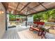 Charming outdoor patio with covered area, lighting, seating, hot tub, and backyard views at 3004 Point Clear Dr, Tega Cay, SC 29708