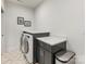 Well-lit laundry room with front load washer, white countertops, and geometric tile floor at 3505 Trent St, Charlotte, NC 28209