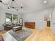 Open living room featuring hardwood floors, coffered wall, stylish leather sofa, and plenty of natural light at 3505 Trent St, Charlotte, NC 28209