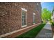 Side view of a brick townhome with neatly trimmed lawn and a well-maintained walkway at 413 Nobles Way, Belmont, NC 28012