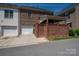 Brick townhouse featuring an attached garage and covered patio with a privacy wall at 413 Nobles Way, Belmont, NC 28012