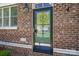 Close-up of a front door featuring glass and brick, with the house number visible at 413 Nobles Way, Belmont, NC 28012