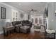 Inviting living room featuring a leather sofa, hardwood floors, and a cozy fireplace with access to outdoor living at 413 Nobles Way, Belmont, NC 28012