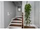 Staircase featuring hardwood steps and a hanging green plant adding a touch of nature to the interior at 413 Nobles Way, Belmont, NC 28012