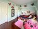 Charming bedroom with a unique bed frame, soft pink rug, and dark wood floors at 4825 Samuel Richard St, Kannapolis, NC 28083