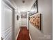 Long hallway with wood-look flooring and decorated with Gathering pictures at 4825 Samuel Richard St, Kannapolis, NC 28083