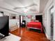 Primary bedroom featuring a red bed, dark wood floors, and a tray ceiling at 4825 Samuel Richard St, Kannapolis, NC 28083