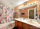 Bathroom with double sinks and a quirky cosmetic themed shower curtain and matching rug at 4825 Samuel Richard St, Kannapolis, NC 28083