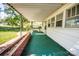 View of the spacious, covered porch with green carpet and brick foundation along the side of the house at 495&501 Turnersburg Hwy, Statesville, NC 28625