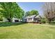 Charming single-story home with a lush front lawn, colorful shrubs, and mature trees on a sunny day at 495&501 Turnersburg Hwy, Statesville, NC 28625