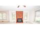 Bright living room with brick fireplace, ceiling fan, and multiple windows offering natural light at 495&501 Turnersburg Hwy, Statesville, NC 28625